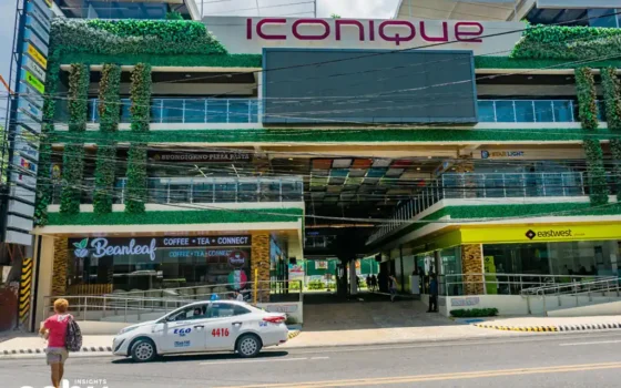 Facade of a shopping mall in Colon Street with a taxi outside