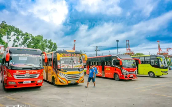 Men walk past buses at a major public transport terminal in Cebu