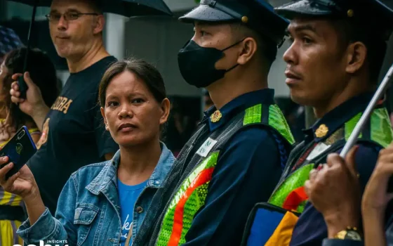 A woman standing next to two police officers during Sinulog
