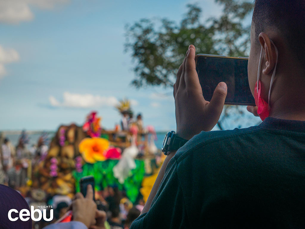 Audience member at the Sinulog Festival taking photos of the parade